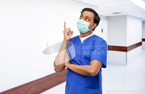 Image of indian male doctor in blue uniform and mask