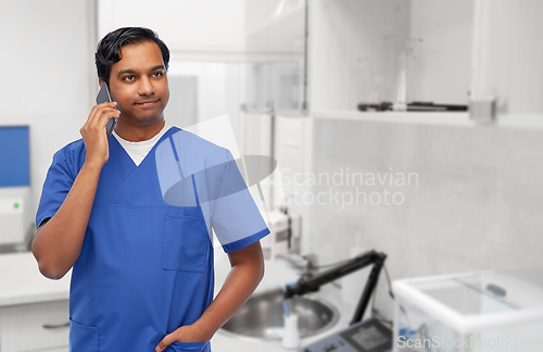 Image of smiling doctor or male nurse calling on smartphone