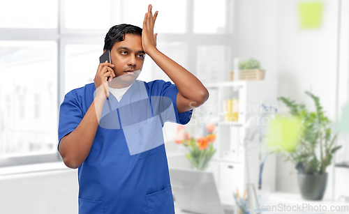 Image of indian doctor or male nurse calling on smartphone