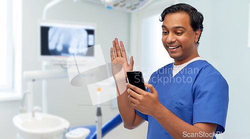 Image of doctor or male dentist having video call on phone