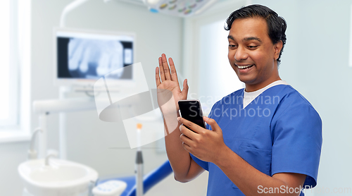 Image of doctor or male dentist having video call on phone