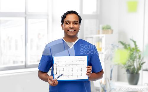 Image of smiling male doctor with cardiogram on clipboard