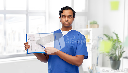 Image of male doctor with cardiogram on clipboard