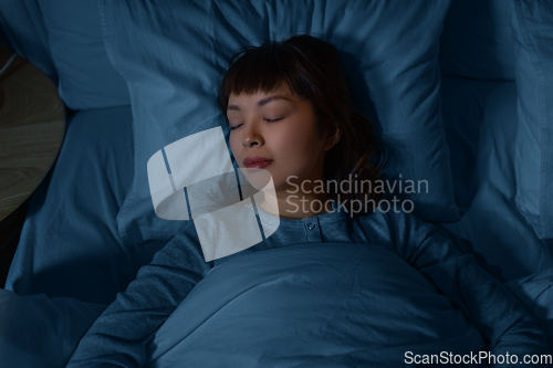 Image of asian woman sleeping in bed at home at night