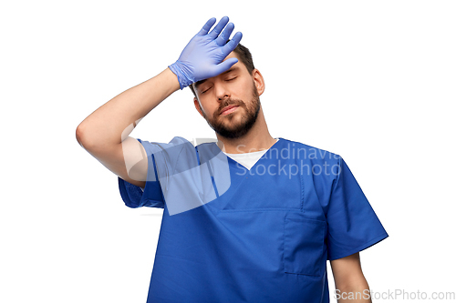 Image of tired doctor or male nurse in blue uniform