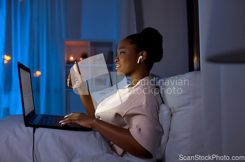 Image of woman with laptop having video call at night