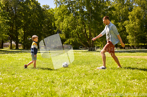 Image of father with little son playing soccer at park