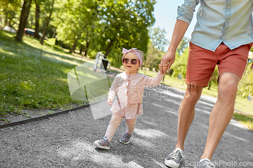 Image of father with baby daughter walking at summer park