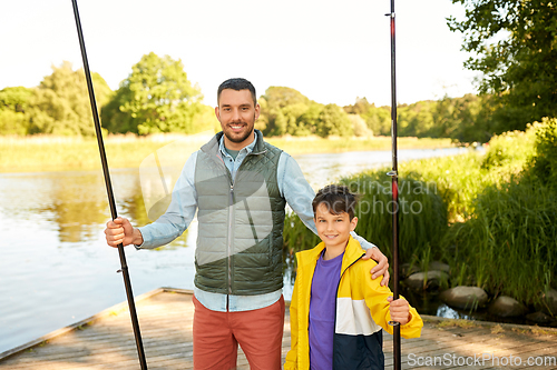 Image of happy smiling father and son fishing on river