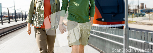 Image of happy couple with backpacks traveling by train