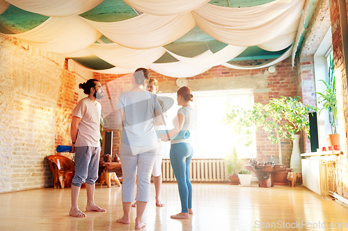 Image of group of people with mats at yoga studio or gym