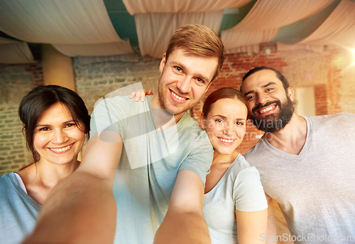 Image of happy friends at yoga studio or gym taking selfie