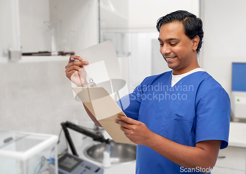 Image of happy indian male doctor with clipboard