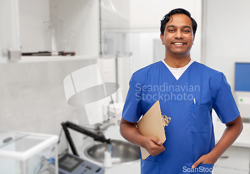 Image of happy smiling indian male doctor with clipboard