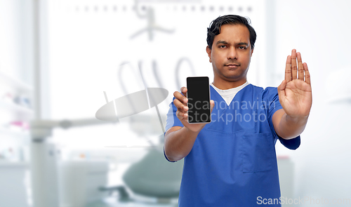 Image of indian male doctor with phone showing stop gesture
