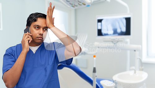 Image of indian doctor or dentist calling on smartphone