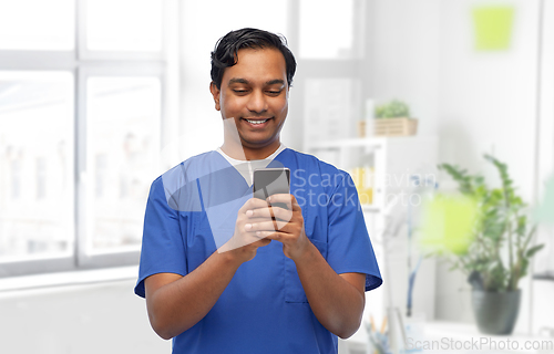 Image of smiling doctor or male nurse using smartphone