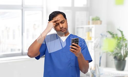 Image of indian doctor or male nurse using smartphone