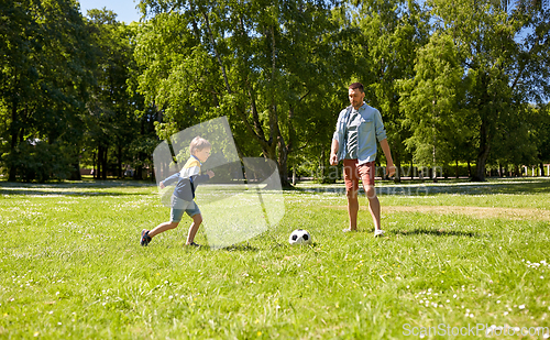 Image of father with little son playing soccer at park