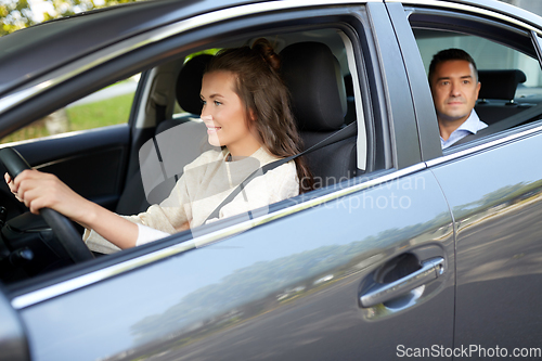 Image of female driver driving car with male passenger