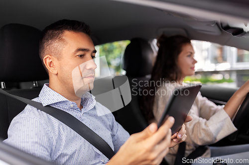 Image of woman and driving school instructor in car