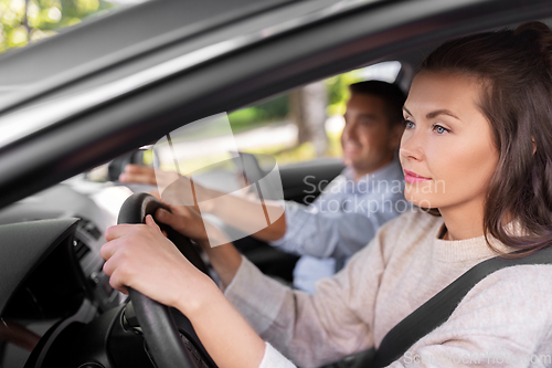 Image of car driving school instructor teaching woman