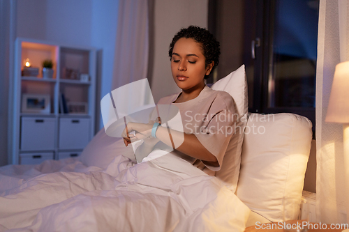 Image of woman with health tracker in bed at night