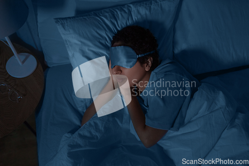 Image of african woman sleeping in bed at home at night