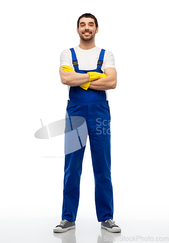Image of happy male worker or cleaner in overal and gloves