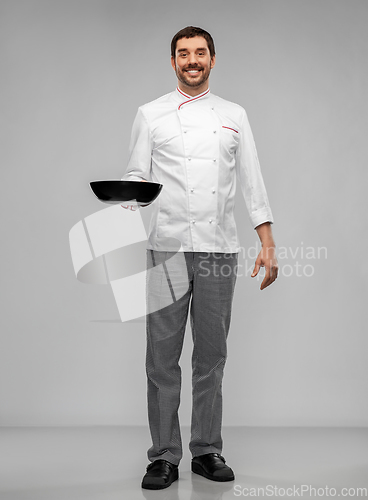 Image of happy smiling male chef in jacket with frying pan