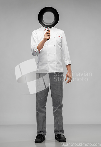 Image of male chef hiding his face over frying pan