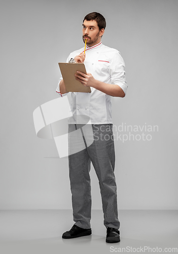 Image of thinking male chef with clipboard and pencil