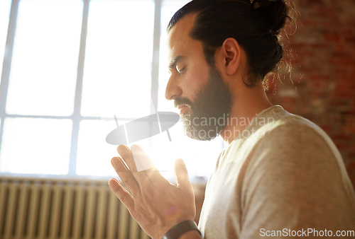 Image of close up of man meditating at yoga studio