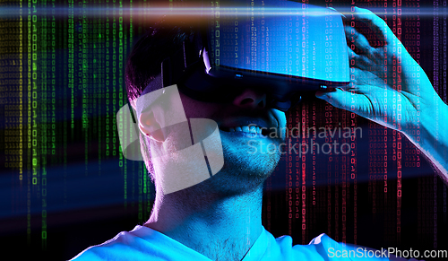 Image of man in vr glasses over neon lights and binary code
