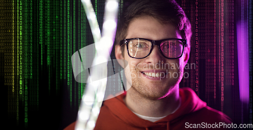 Image of man in glasses over neon lights and binary code