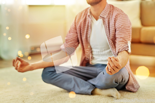 Image of close up of man meditating at home