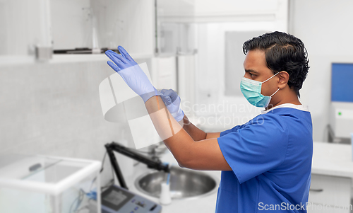 Image of indian male doctor in uniform, mask and gloves