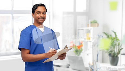 Image of male doctor writing medical report on clipboard