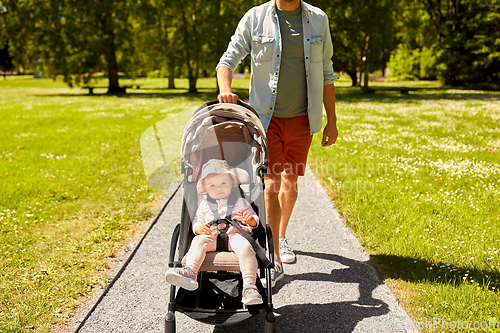 Image of father with child in stroller at summer park