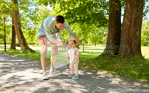 Image of happy father with baby daughter at summer park