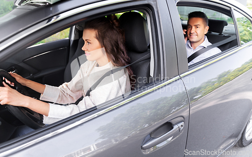 Image of female driver driving car with male passenger