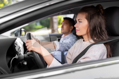 Image of car driving school instructor teaching woman