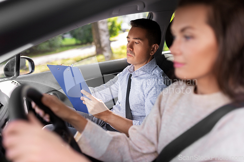 Image of car driving school instructor and young driver