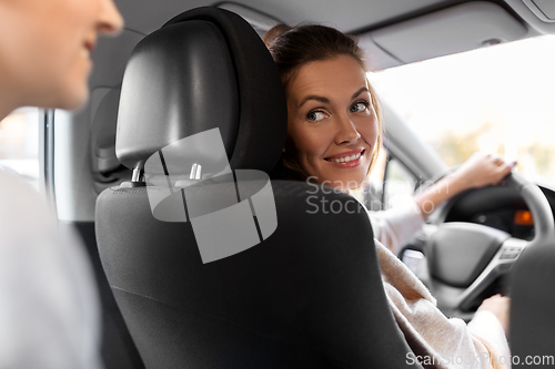 Image of female driver driving car with passenger