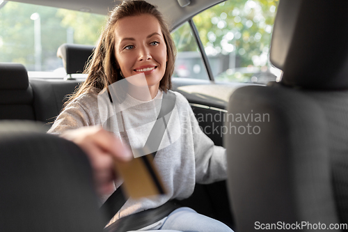 Image of female passenger giving credit card to taxi driver