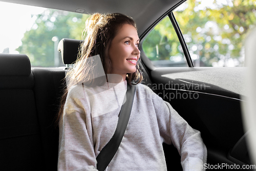 Image of smiling woman or female passenger in taxi car