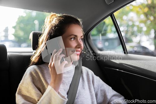 Image of woman in taxi car calling on smartphone