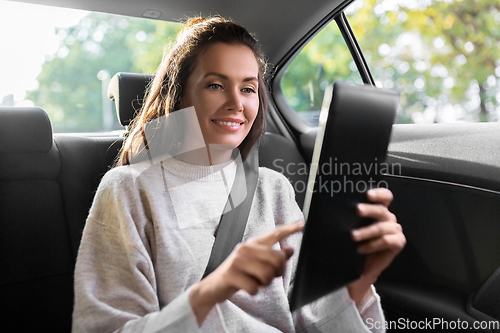 Image of smiling woman in taxi car using tablet pc computer