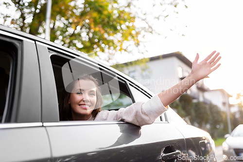 Image of happy smiling woman or female passenger in car