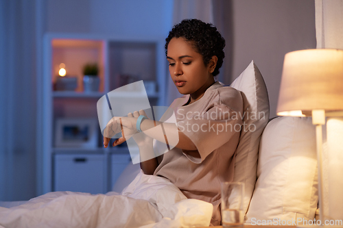 Image of woman with health tracker in bed at night